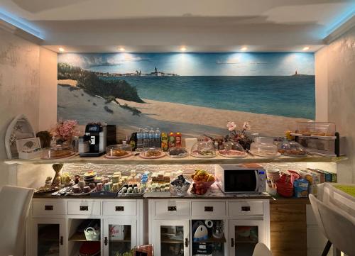 a kitchen with a painting of a beach at Acqua Azzurra in Alghero