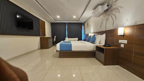 a hotel room with a bed and a television at West Bay MARISOL in Varkala