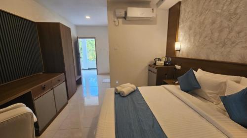 a bedroom with a bed and a dresser in it at West Bay MARISOL in Varkala