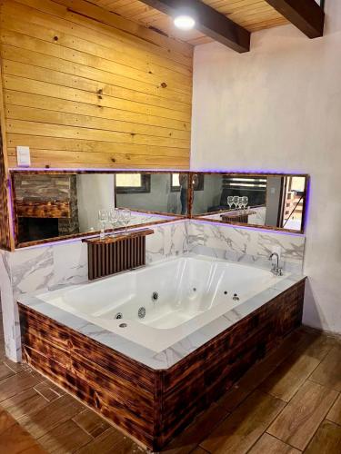 a large white tub in a room with wooden ceilings at Cabaña en Mazamitla - Onix in Mazamitla