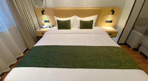 a large white bed in a hotel room at GreenTree Inn Ganzhou Gan County Bus Station in Ganzhou