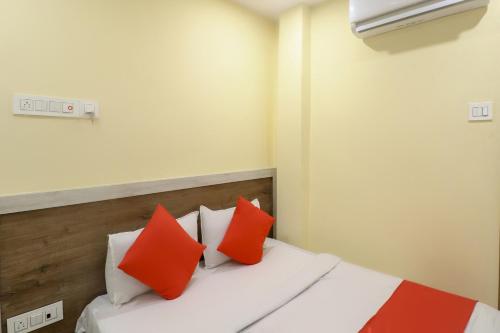 a bedroom with a bed with red and white pillows at Hotel O 67309 Hotel Tuk Tuk Palace in Rānchī