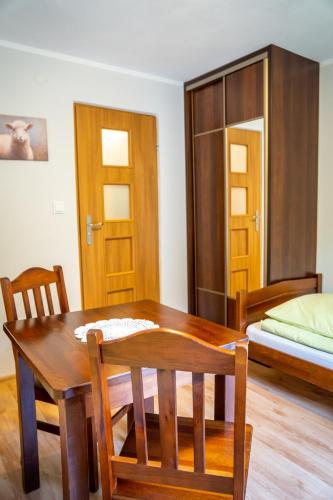 a room with a table and chairs and a bed at Pokoje Gościnne Na Szlaku in Krościenko