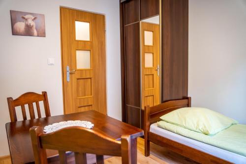a bedroom with a table and a bed and a door at Pokoje Gościnne Na Szlaku in Krościenko