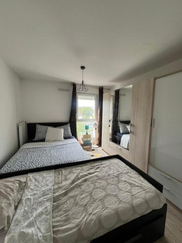 une chambre avec un grand lit dans une pièce dans l'établissement Entire Simple, cozy family apartment, à Thorigny-sur-Marne