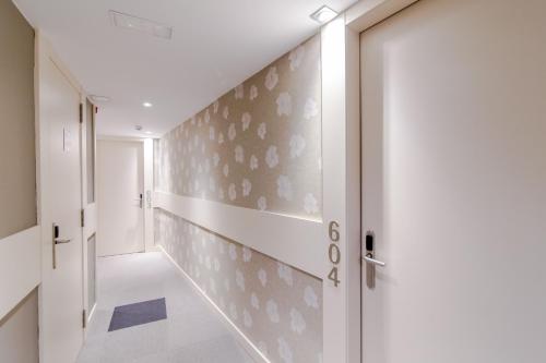 a hallway with a white door and a wall withletters at Hotel Santa Marta in Barcelona