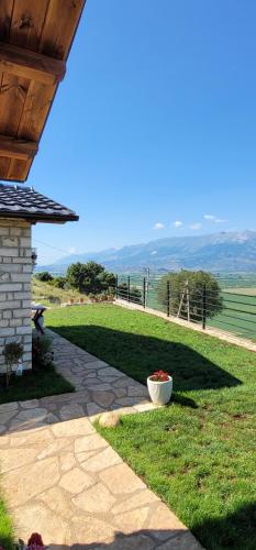 a porch with a vase of flowers in the grass at Ballkoni i Goricës in Goricë