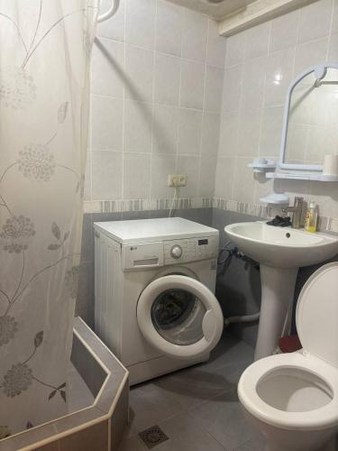 a bathroom with a toilet a sink and a washing machine at Cozy corner Dilijan in Dilijan