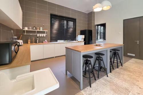 a large kitchen with a counter and stools in it at Luxury Villa Kristal Seksyen 7, Shah Alam - Smarthome in Shah Alam