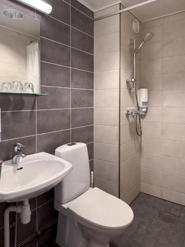 a bathroom with a toilet and a sink at Hotelli Joentalo in Tornio