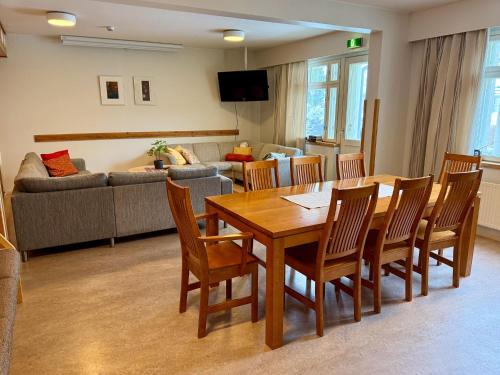 a living room with a table and chairs and a couch at Hotelli Joentalo in Tornio
