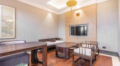 a living room with two tables and a tv at Xian Huaqingyutang Hotel in Xi'an