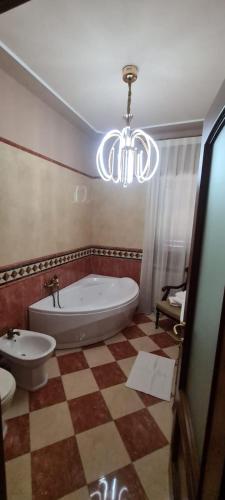 a bathroom with a tub and a sink and a chandelier at B&B Montisclari in Monchiero