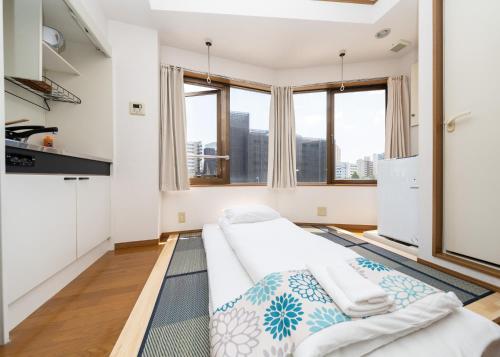 Una sala de estar con un sofá y algunas ventanas. en 匯金芝浦ビル, en Tokio