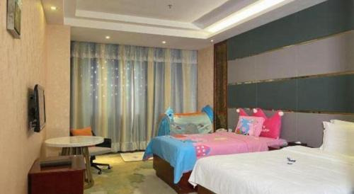 a hotel room with two beds and a television at Shenzhen Kai Long International Hotel in Shenzhen