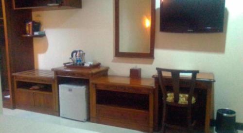 a kitchen with a desk and a television and a chair at Yusro Hotel Restaurant & Convention in Jombang