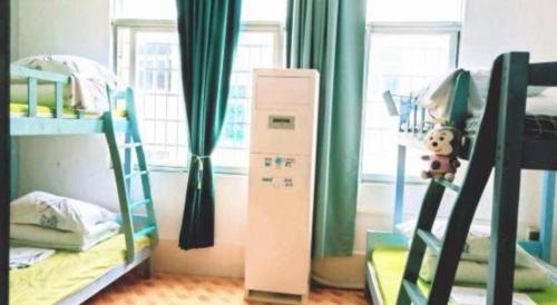 a dorm room with two bunk beds and a window at Beihai forget dust International Youth Hostel in Beihai