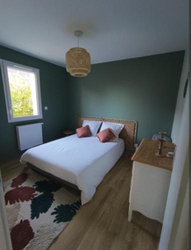 une chambre avec un lit, une table et une fenêtre dans l'établissement les galets de Normandie, à Biville-sur-Mer