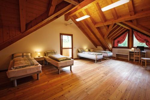 トルメッツォにあるAlbergo Diffuso Tolmezzoの木製の天井のベッドルーム1室(ベッド3台付)