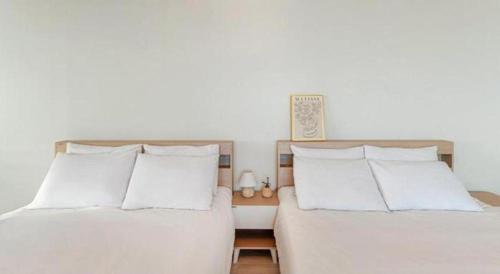 two beds sitting next to each other in a bedroom at Gallery Pension in Taean