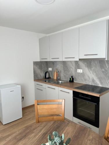 a kitchen with white cabinets and a black stove top oven at Apartmani Pervan 2 in Livno