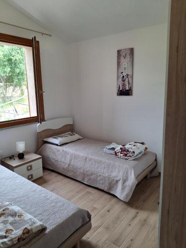a bedroom with two beds and a window at Villa Margherita in Chia