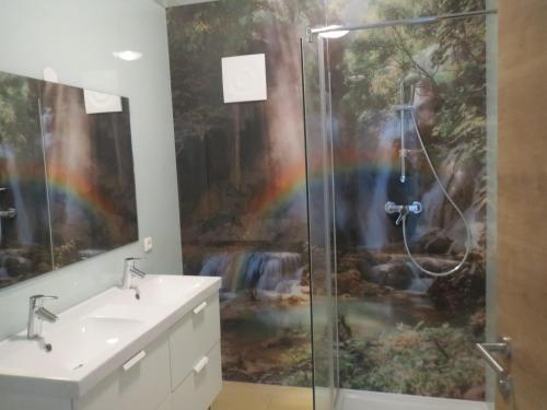 a bathroom with a shower with a rainbow painting on the wall at Gasthof Maly in Mauthausen