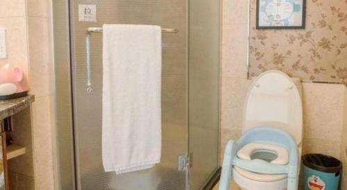 a bathroom with a shower with a toilet and a towel at Fortune International Hotel in Xiawutun