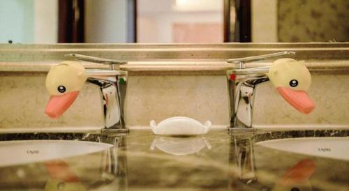 a bathroom with three sinks with rubber ducks on them at Fortune International Hotel in Xiawutun