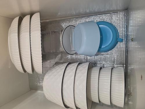 a bunch of plates and a blue mug on a rack at The Anderson by Triple G Homes in Ipoh