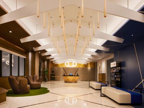 a lobby with a large chandelier in a building at ES CON FIELD HOKKAIDO HOTEL Kitahiroshima Station in Kitahiroshima