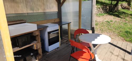un patio con piano cottura, tavolo e sedie. di Le Temps Suspendu a Saint-Pierreville