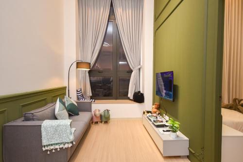 a living room with a couch and a window at Sunway Grid Loft Suite by Nest Home【Olympic Size Pool】 in Kampong Pendas