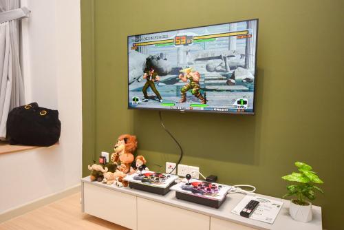 a room with a tv on a wall with toys at Sunway Grid Loft Suite by Nest Home【Olympic Size Pool】 in Kampong Pendas