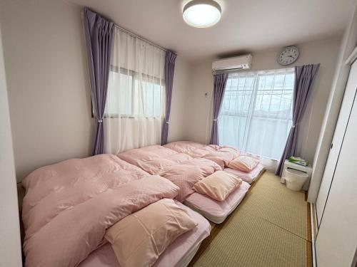 寝屋川市にある一棟貸しの宿 貸別荘 寝屋川ハウス NEYAGAWA HOUSE! for up to 10 people, 3 min walk from Keihan Kayashima Station, 京阪電車 萱島駅から徒歩3分, キーボックスの暗証番号はご予約後に宿からのメッセージ欄にてご確認下さい,の窓付きの部屋のベッド1台(ピンクのシーツ付)