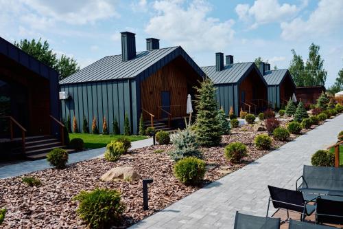a row of wooden buildings with a garden at Сімейний Екопарк Ясногородка in Yasnogorodka