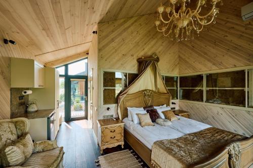 a bedroom with a bed and a chandelier at Сімейний Екопарк Ясногородка in Yasnogorodka