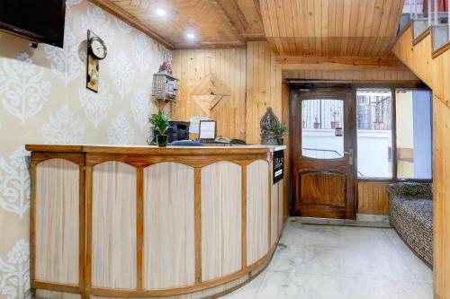 a kitchen with a bar in a room with wooden walls at Super Collection O Mall Road Formerly Hotel Shubham in Shimla