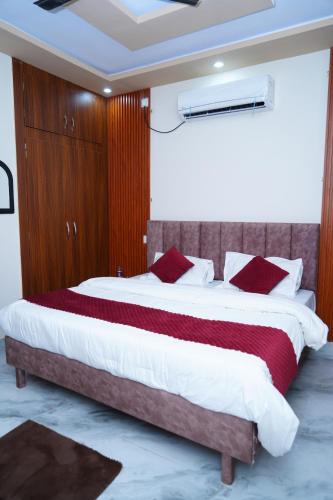 a bedroom with a large bed with red pillows at UrbanOak HOMESTAY in Haldwāni