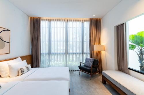 a hotel room with two beds and a window at Botanika Estate Private Pool Villa in Canggu
