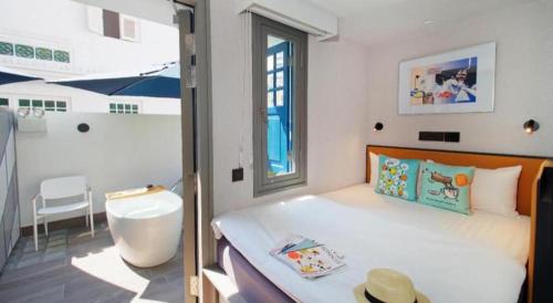 a bedroom with a large bed and a window at Hotel Soloha @ Chinatown in Singapore