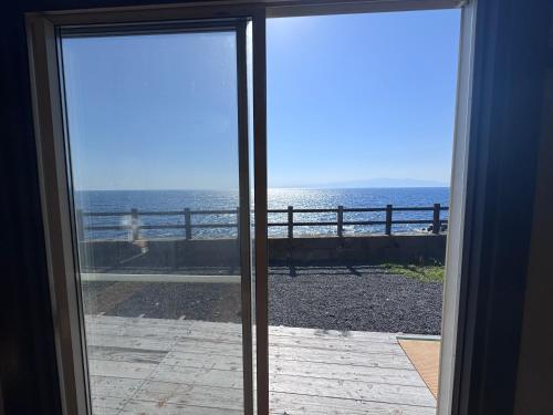a view of the ocean from a sliding glass door at Villa Thalassa 貸切 in Oshima