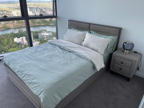 a bedroom with a large bed with a large window at Queens Wharf 50th Floor in Brisbane