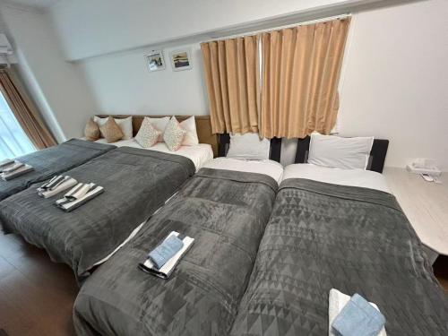 a hotel room with two beds with towels on them at JR Shin-Osaka 2mins, Direct to Kansai Airport 關西空港直達,Shinkansen to Tokyo, Tokyo & Nagoya, Universal Studio 16 mins, Umeda 6 mins, Kyoto 25 mins, Early Check-In in Osaka