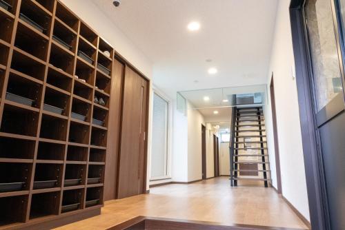 a walk in wine cellar with wooden cabinets and a glass door at 八戸駅西口民泊ゲストルームNvillage in Hachinohe