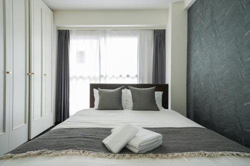 a bedroom with a large bed with two pillows at MP STYLE SAPPORO-37 in Minami-jūichijō