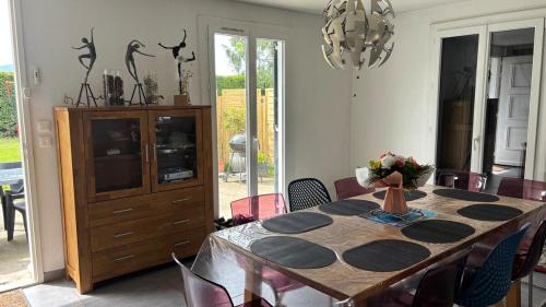 une table à manger avec des chaises et un lustre dans l'établissement La Lémania, à Messery