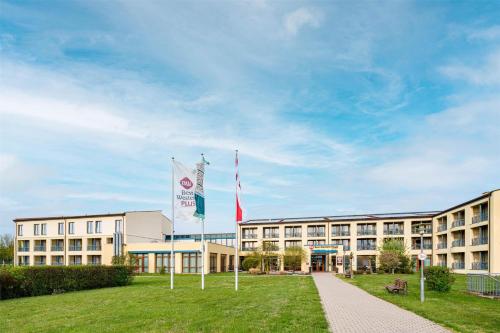 a building with two flags in front of it at Best Western Plus Kurhotel an der Obermaintherme in Bad Staffelstein