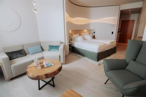 a hotel room with a bed and two chairs and a table at Best Western Plus Kurhotel an der Obermaintherme in Bad Staffelstein