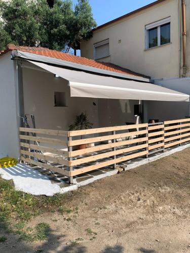 a building with a fence and an awning at Meraki Seaside Apartment in Stavros